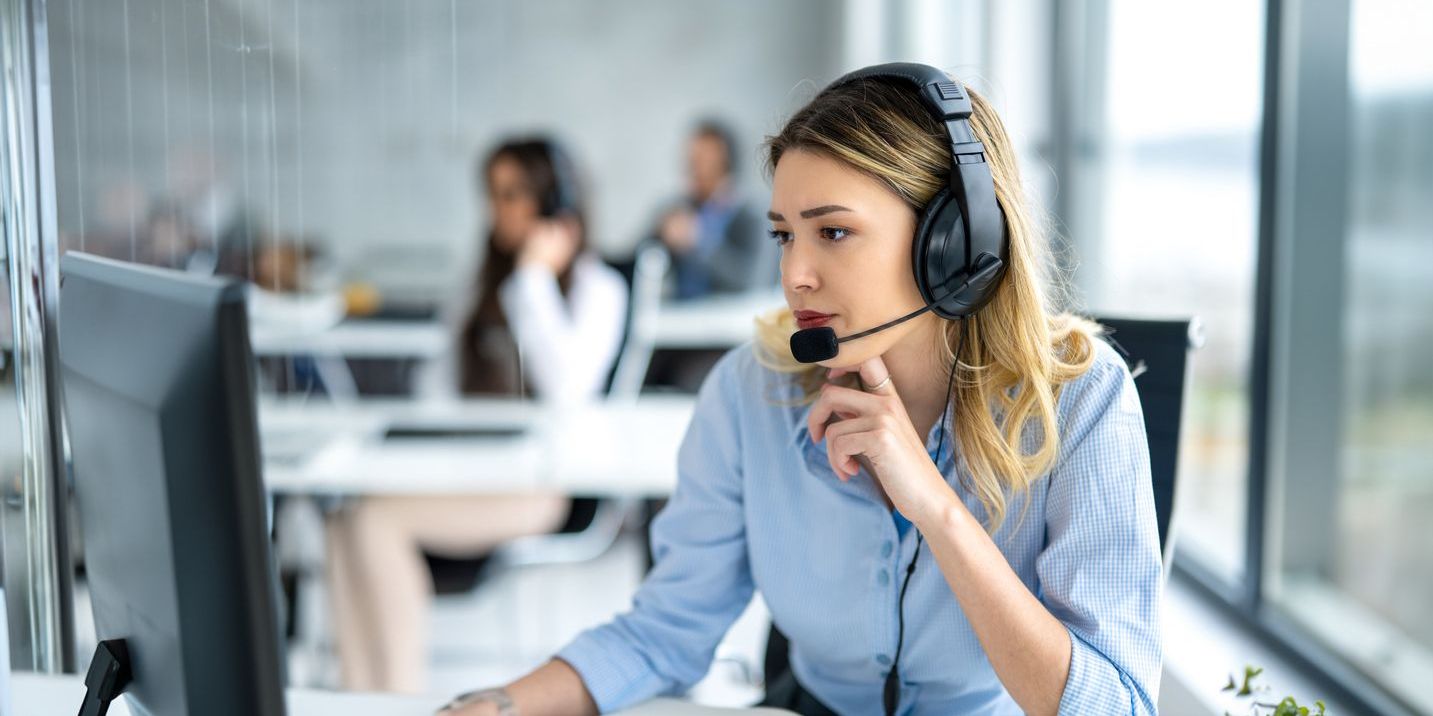 A chat support agent looking at her computer, working at her desk.