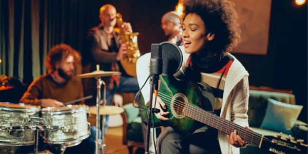 A singer on stage singing with her band.