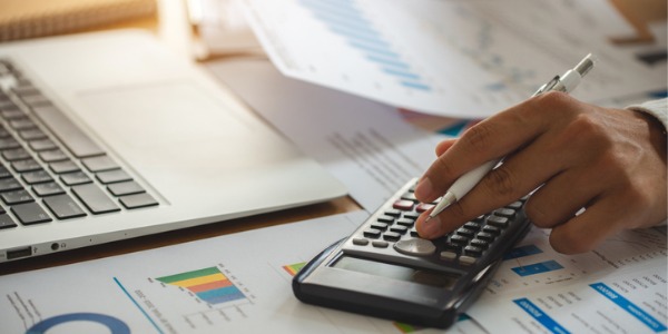 A treasurer working at his desk, using a calculator.