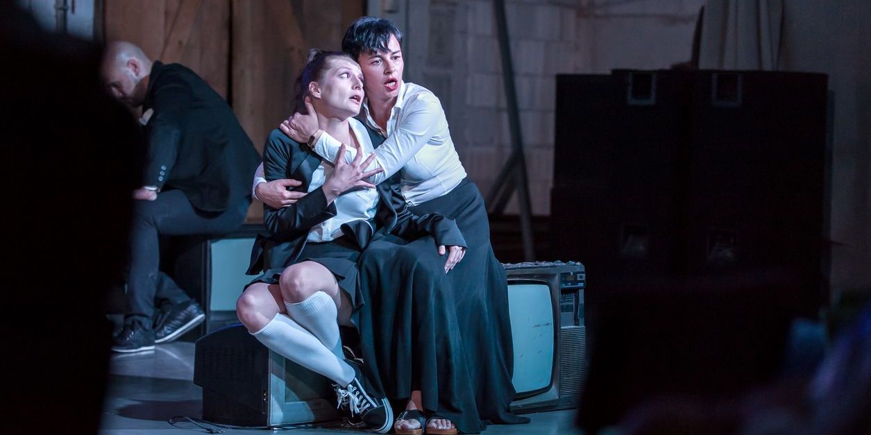 Two stage actors performing in front of an audience.