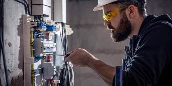 An electrician troubleshooting an electrical wiring system.