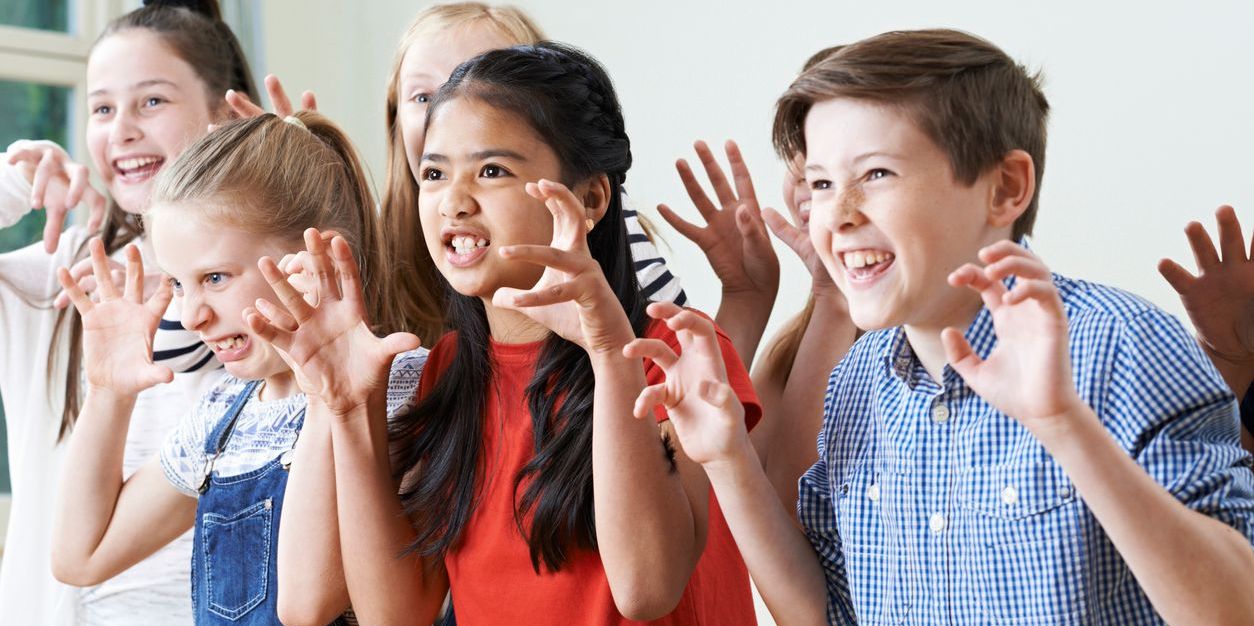 School children practicing scary faces for a school play.